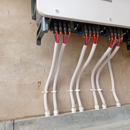 A solar panel mounted on a wall, showcasing its connection for energy generation.